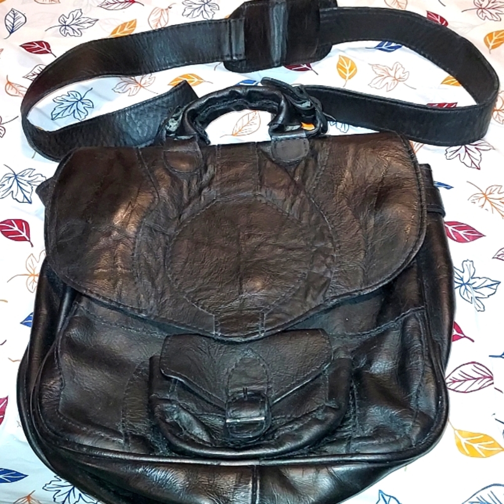 An all leather knapsack that is unisex.